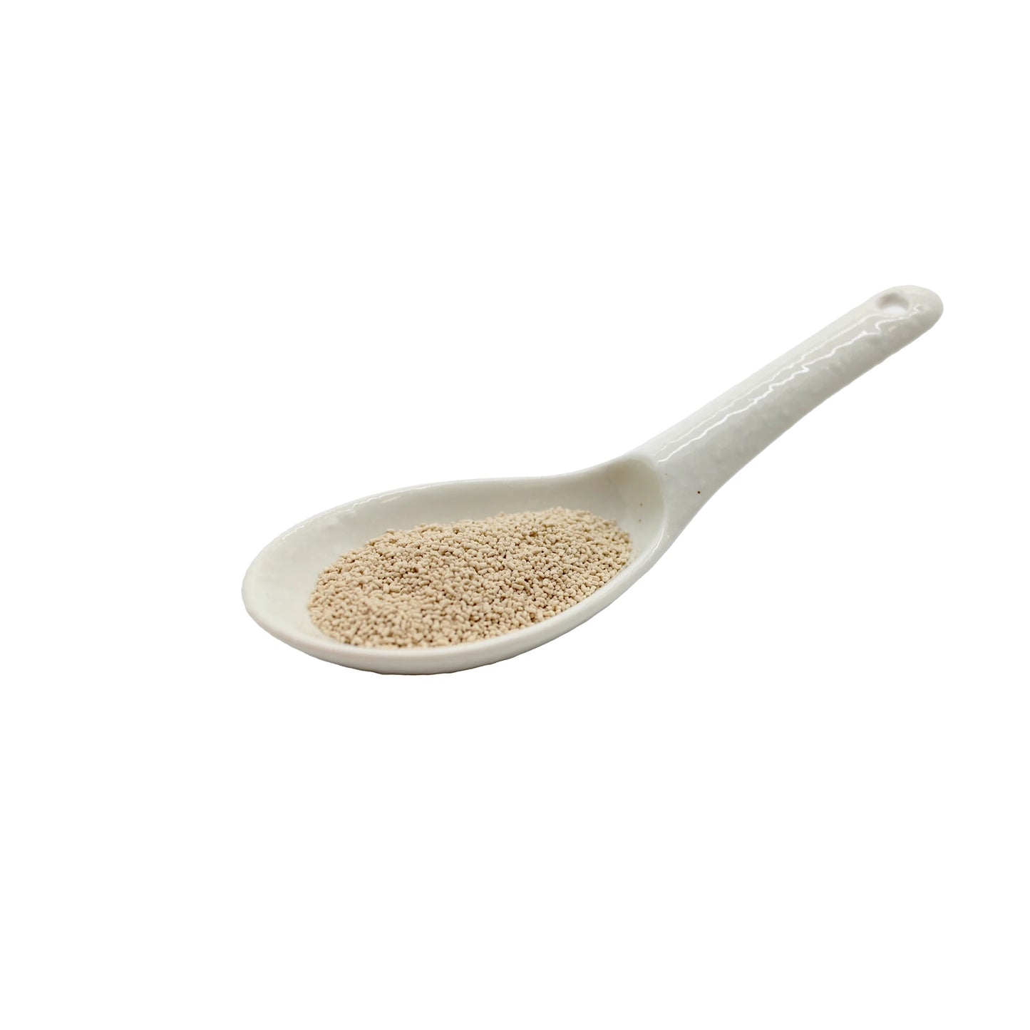 
                  
                    A white ceramic spoon holds a small amount of Shinmaya Bonito Fish Dashi Powder, a dry granular seasoning commonly used in Japanese dishes, photographed against a white background.
                  
                