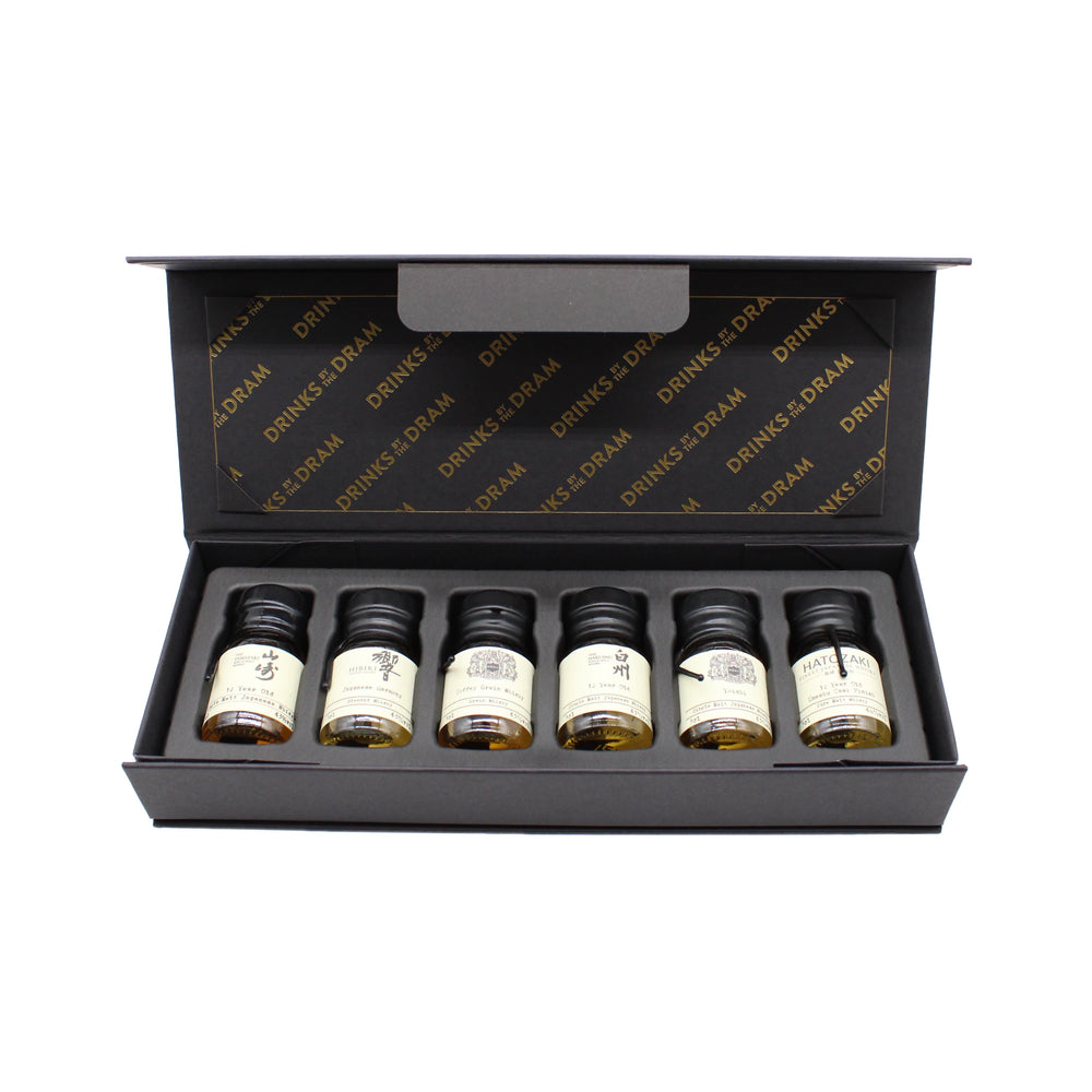 The Japanese Whisky Premium Tasting Set features six small labeled bottles—including Japanese whiskies like Yamazaki 12 Year Old—neatly presented in a black box with a foam insert and an open lid.