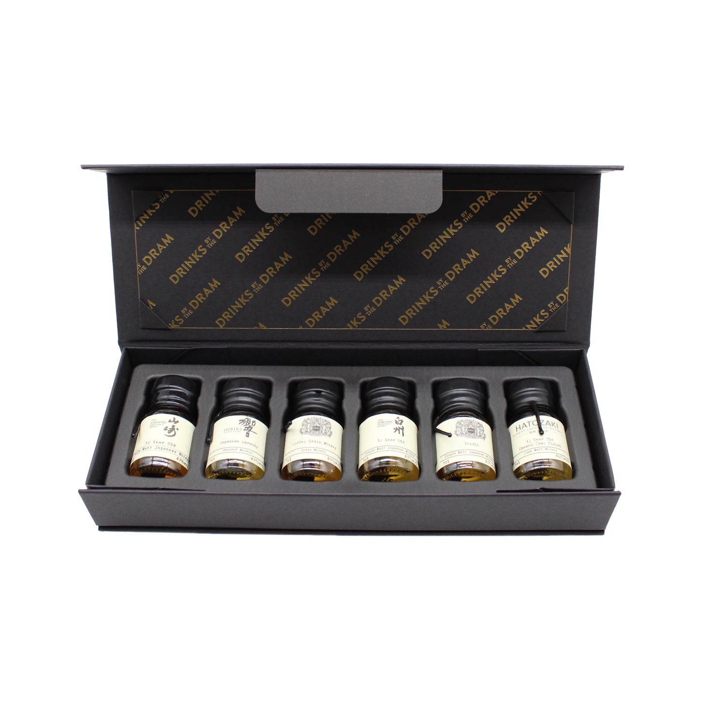 The Japanese Whisky Premium Tasting Set features six small labeled bottles—including Japanese whiskies like Yamazaki 12 Year Old—neatly presented in a black box with a foam insert and an open lid.