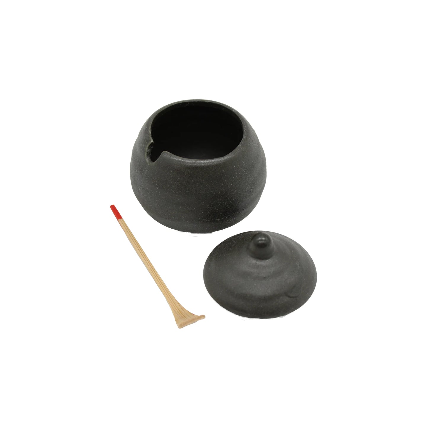 
                  
                    The Karashi / Shichimi Spice Pot - Black Bizen, featuring a removable lid, sits beside a slim bamboo tool with a red tip on a white background—a refined piece of Japanese pottery ideal for storing shichimi spice.
                  
                