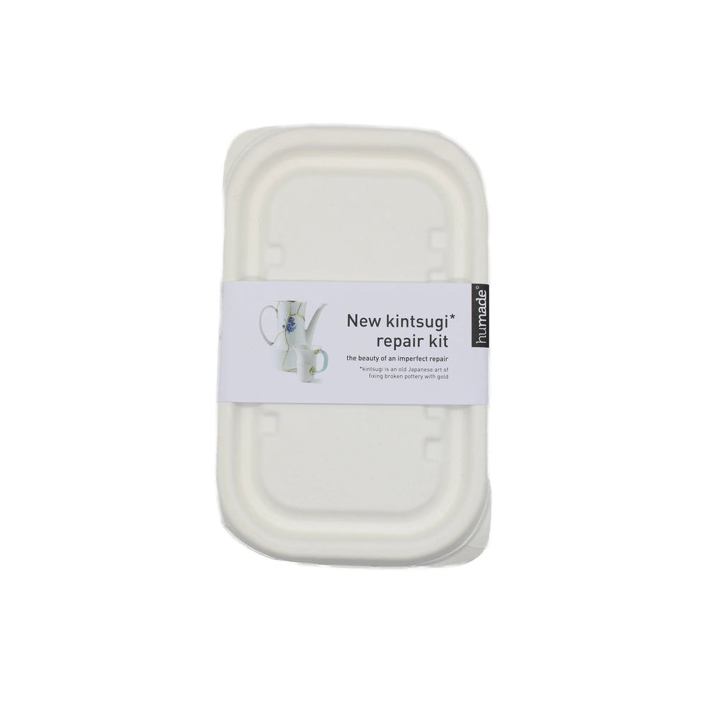 A rectangular white box labeled Kintsugi Kits - Gold, Silver & Bronze features an image of a cup with a striking metallic repair on the packaging.