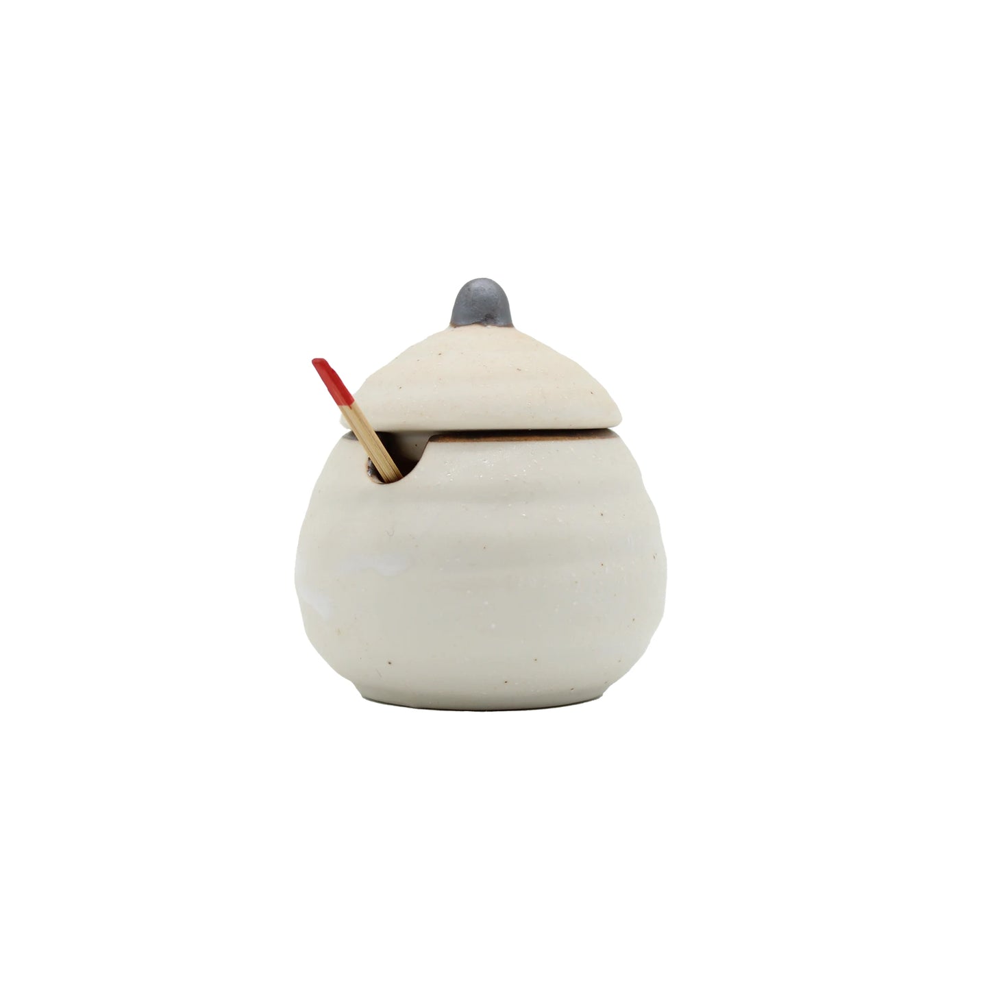 
                  
                    The Karashi / Shichimi Spice Pot - White Kohiki is a white ceramic pot with lid and a small opening for a wooden spoon with a red tip, inspired by Japanese pottery, set against a plain white background.
                  
                