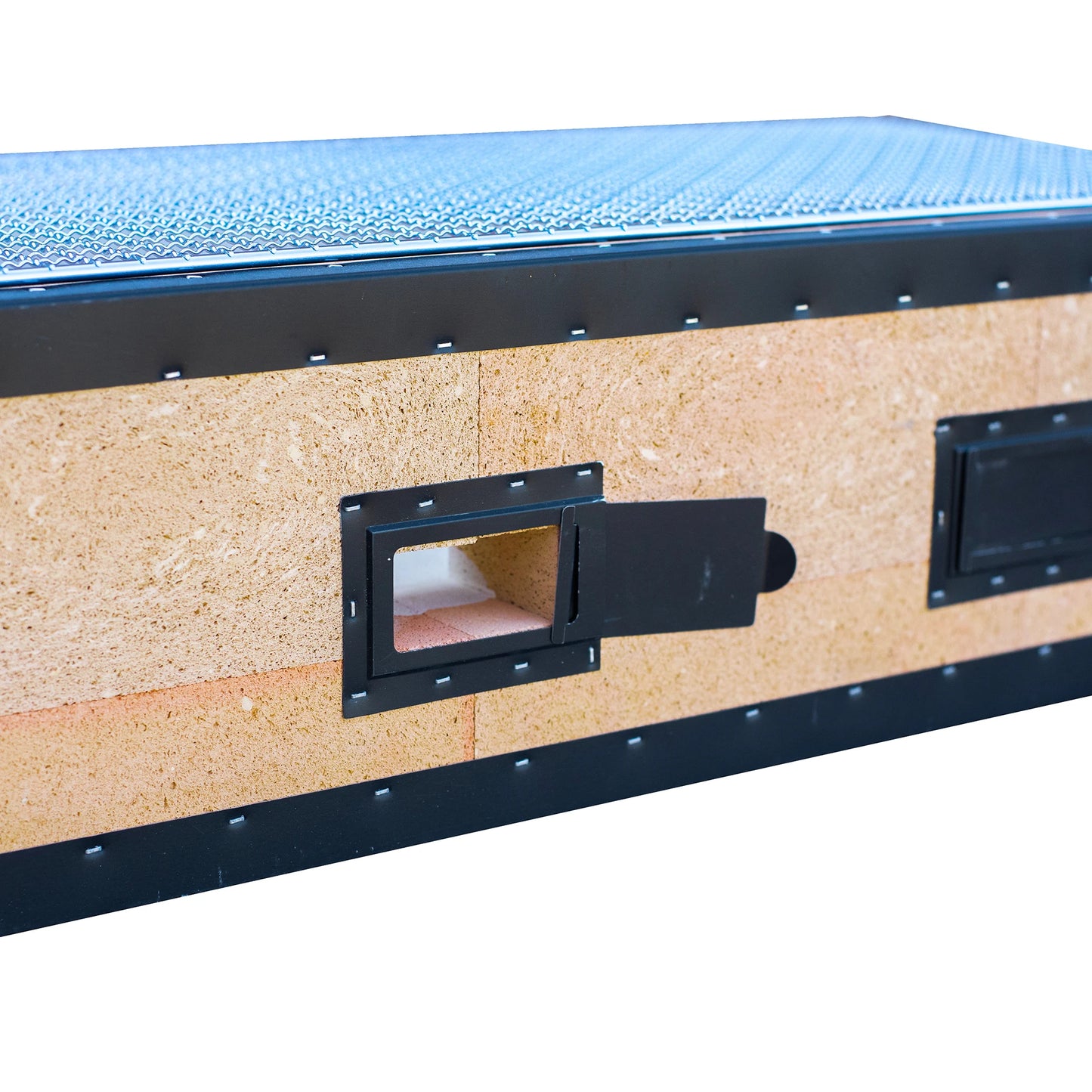 
                  
                    Close-up of the Konro Grill, Table Barbecue - 69cm, a rectangular Japanese charcoal grill with a textured top and reinforced edges, featuring a small open metal door that reveals its interior.
                  
                