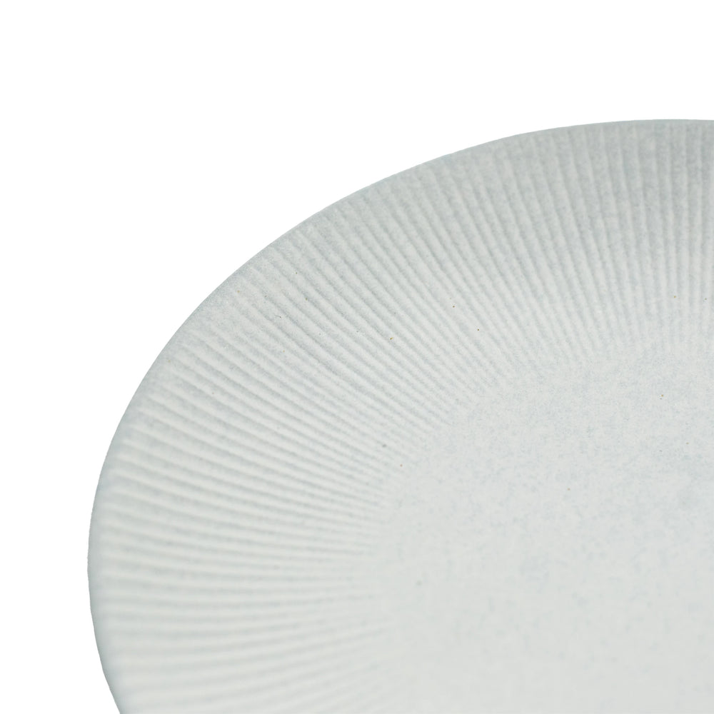 Close-up of the edge of a white, textured Large Plate - Snow Leaf, featuring a radial pattern reminiscent of Minoyaki porcelain plates crafted at the Dai kiln.