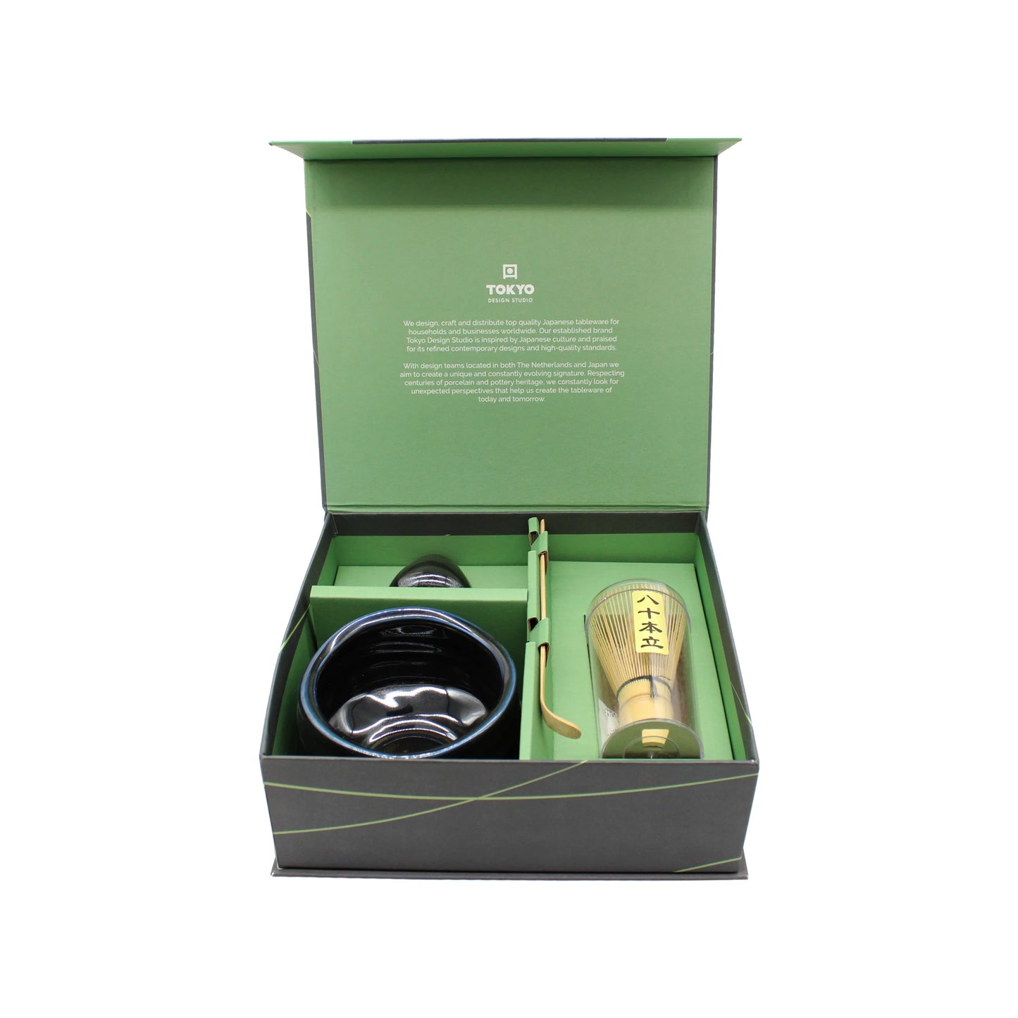The Matcha Tea Set - Black comes in a green box and is designed for Japanese tea ceremonies, featuring a black bowl, bamboo whisk, scoop, and container.