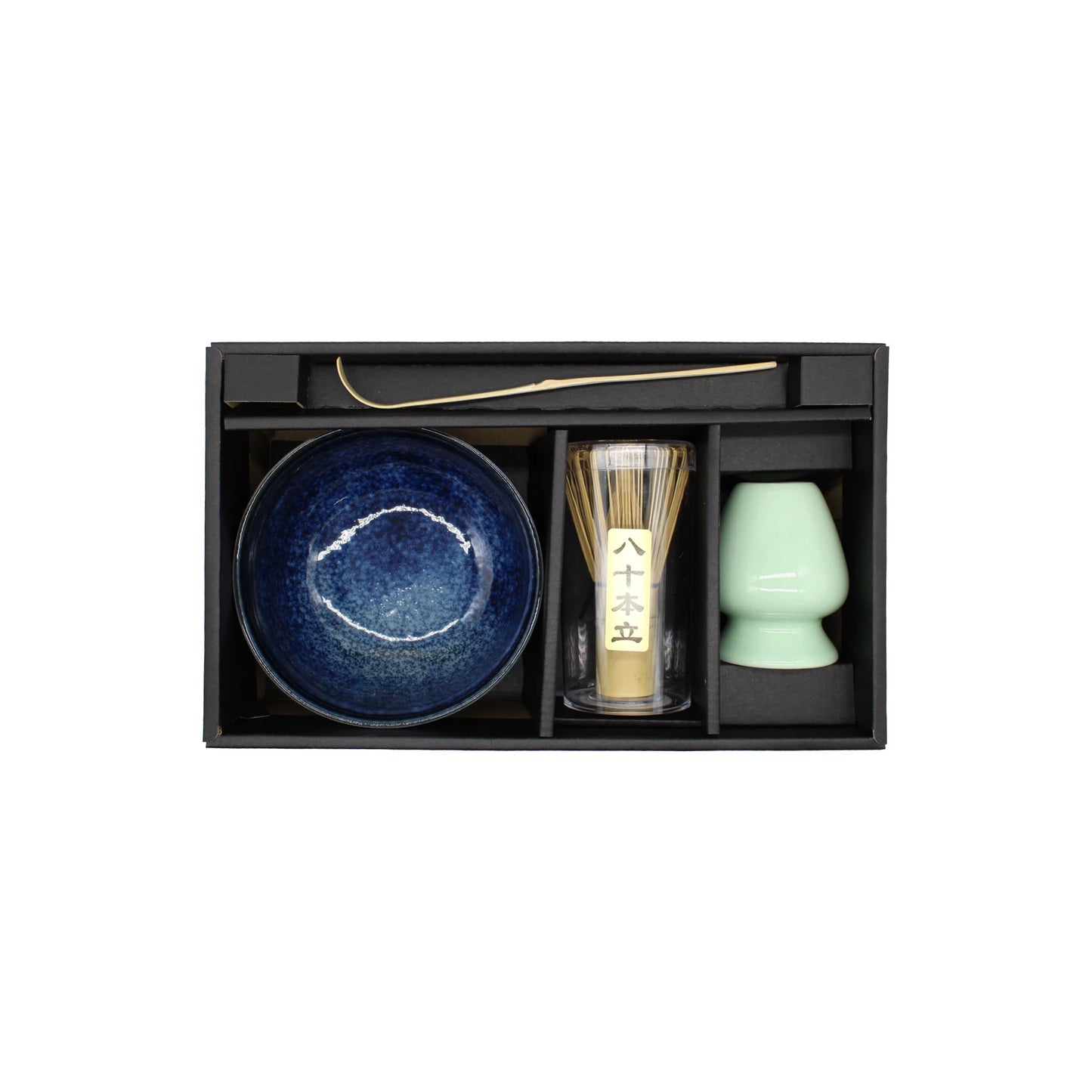 The Matcha Tea Set - Blue includes a blue bowl, bamboo whisk, green cup, gold scoop, and black tray, all neatly arranged in separate compartments within a boxed set.