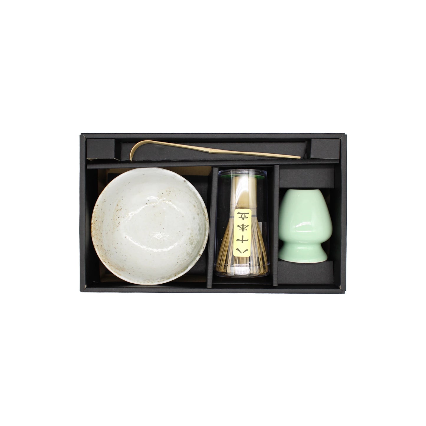 The Matcha Tea Set - Yukishino includes a ceramic bowl, whisk, scoop, and green cup, all arranged in separate compartments within a sleek black box for brewing authentic Japanese matcha tea.