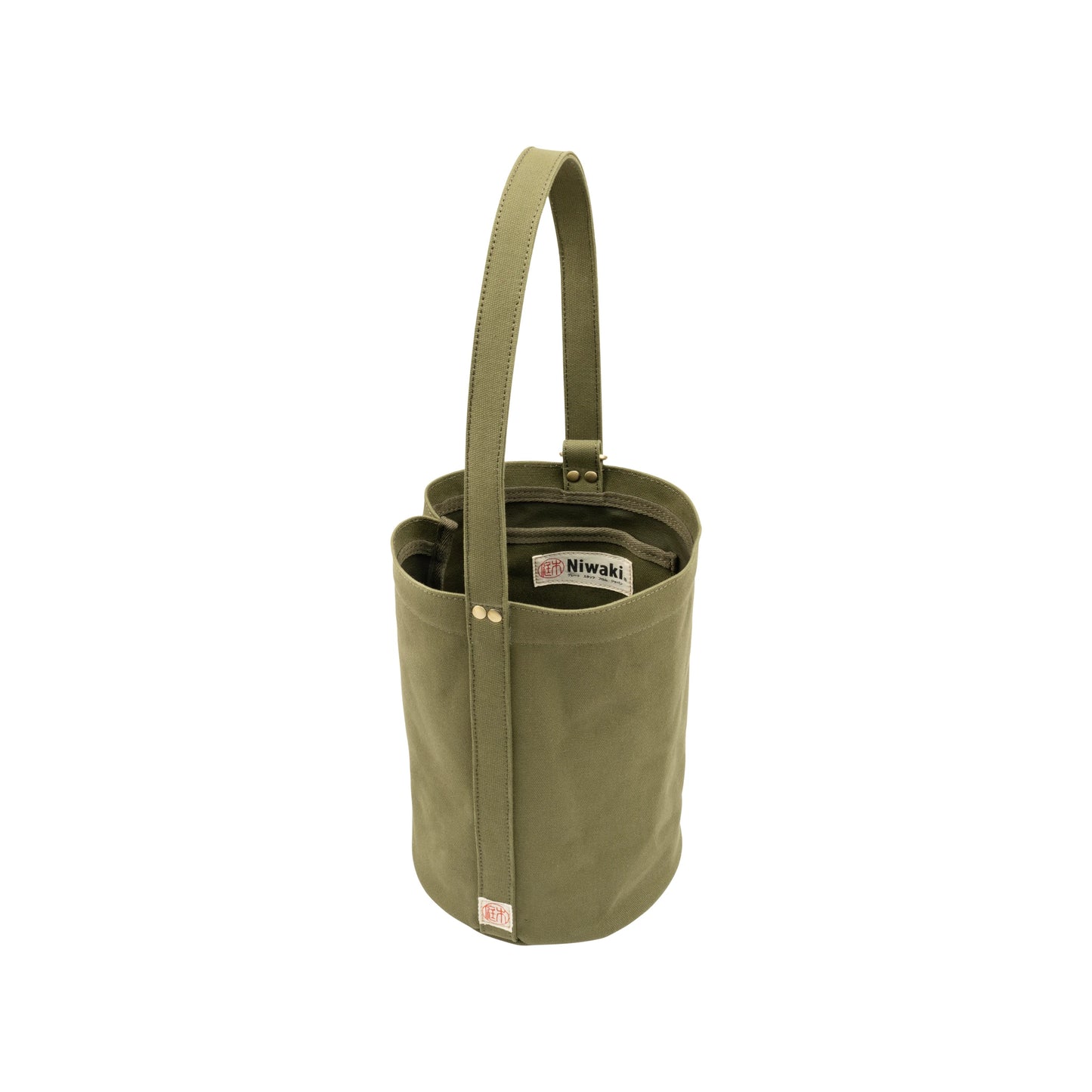 The Mini Kantan Bag - Green is an olive green cylindrical bucket bag made from water-resistant canvas, featuring a single handle, stitched label, internal pockets, and visible rivets for stylish everyday use.