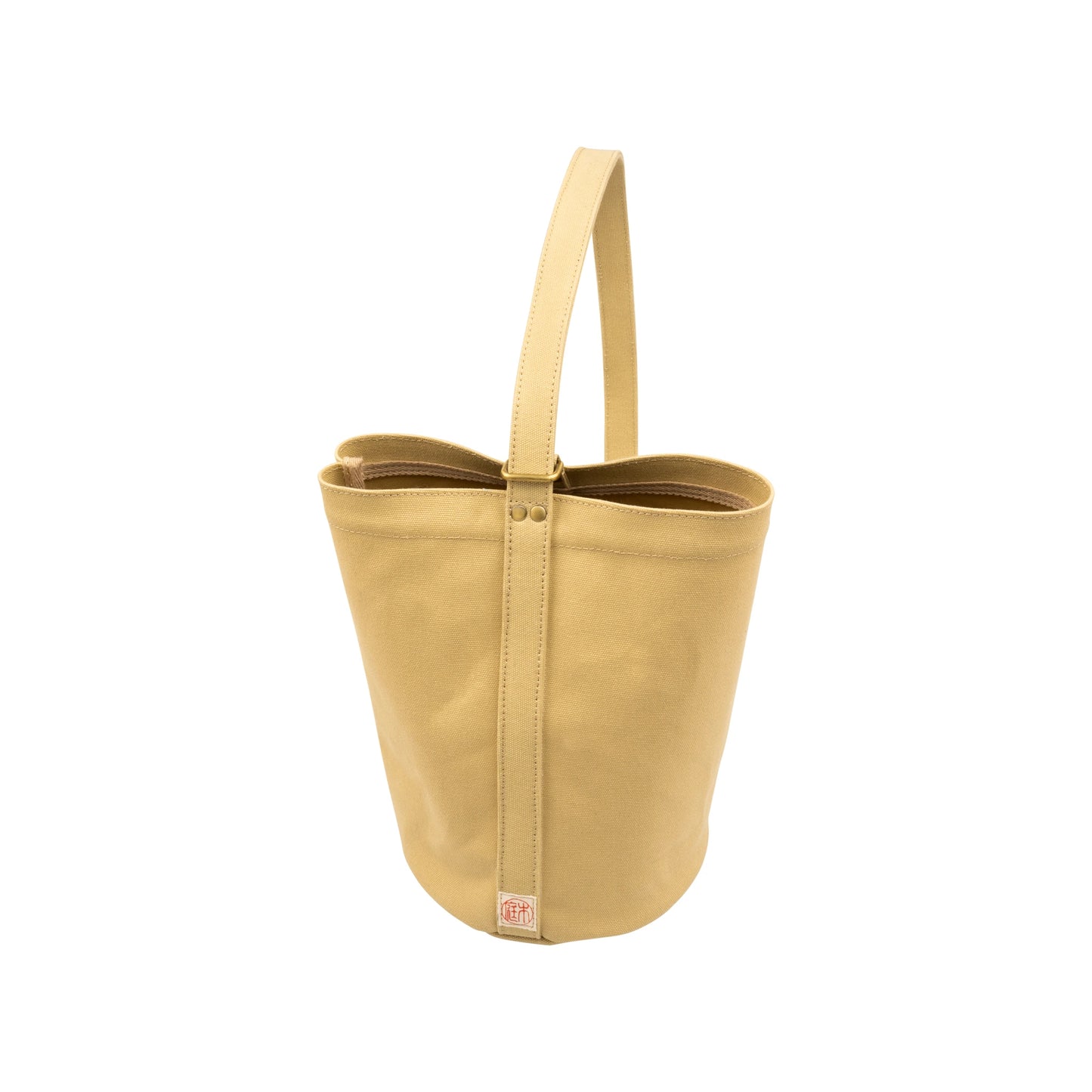 The Mini Kantan Bag - Tan, crafted from water-resistant canvas with a single handle, stands upright on a white background—an ideal choice for your everyday bucket bag.
