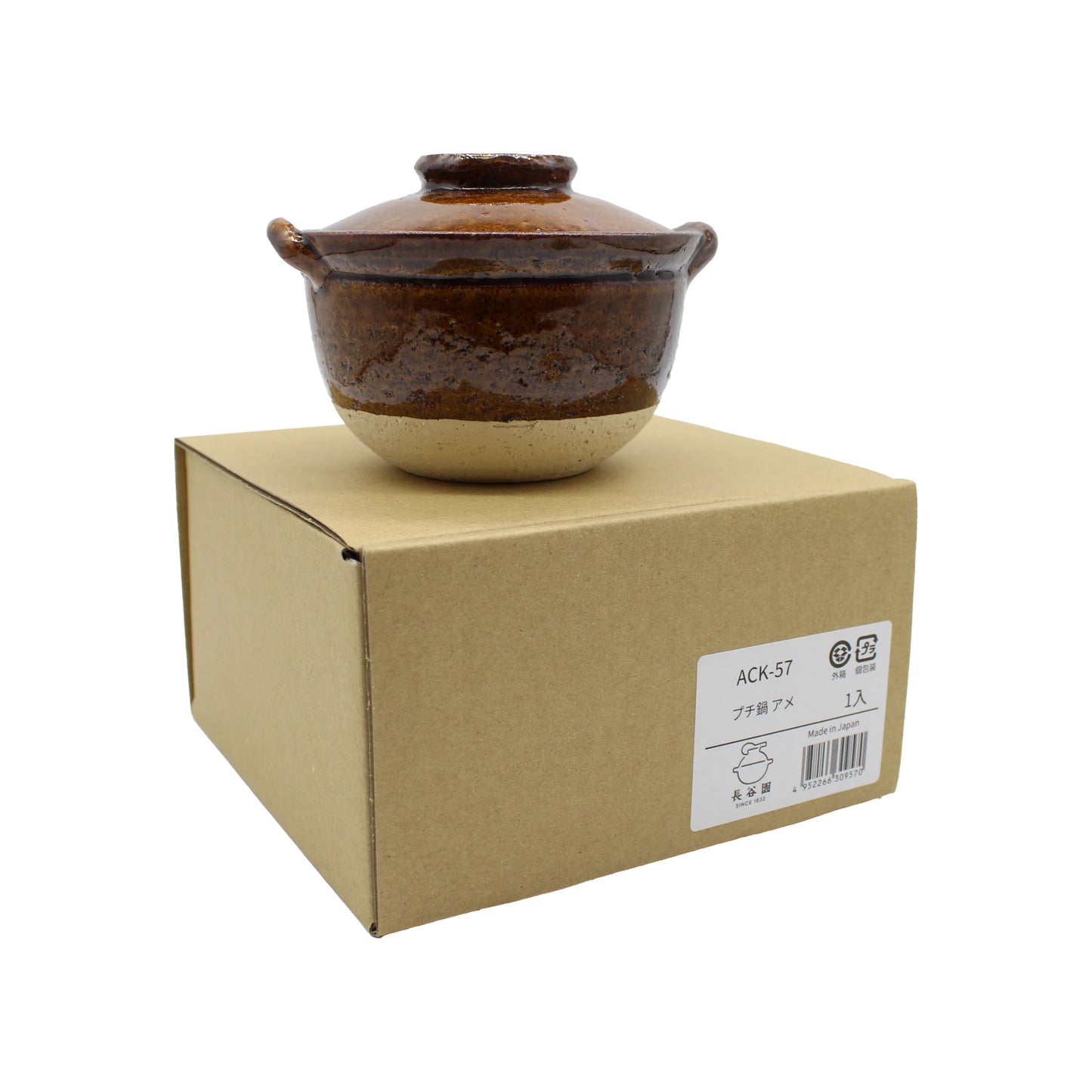 
                  
                    A Mini Donabe Pot - Ame, a small brown ceramic pot featuring handles and a lid, sits atop a closed cardboard box labeled with product information, highlighting the charm of Japanese handmade tableware.
                  
                