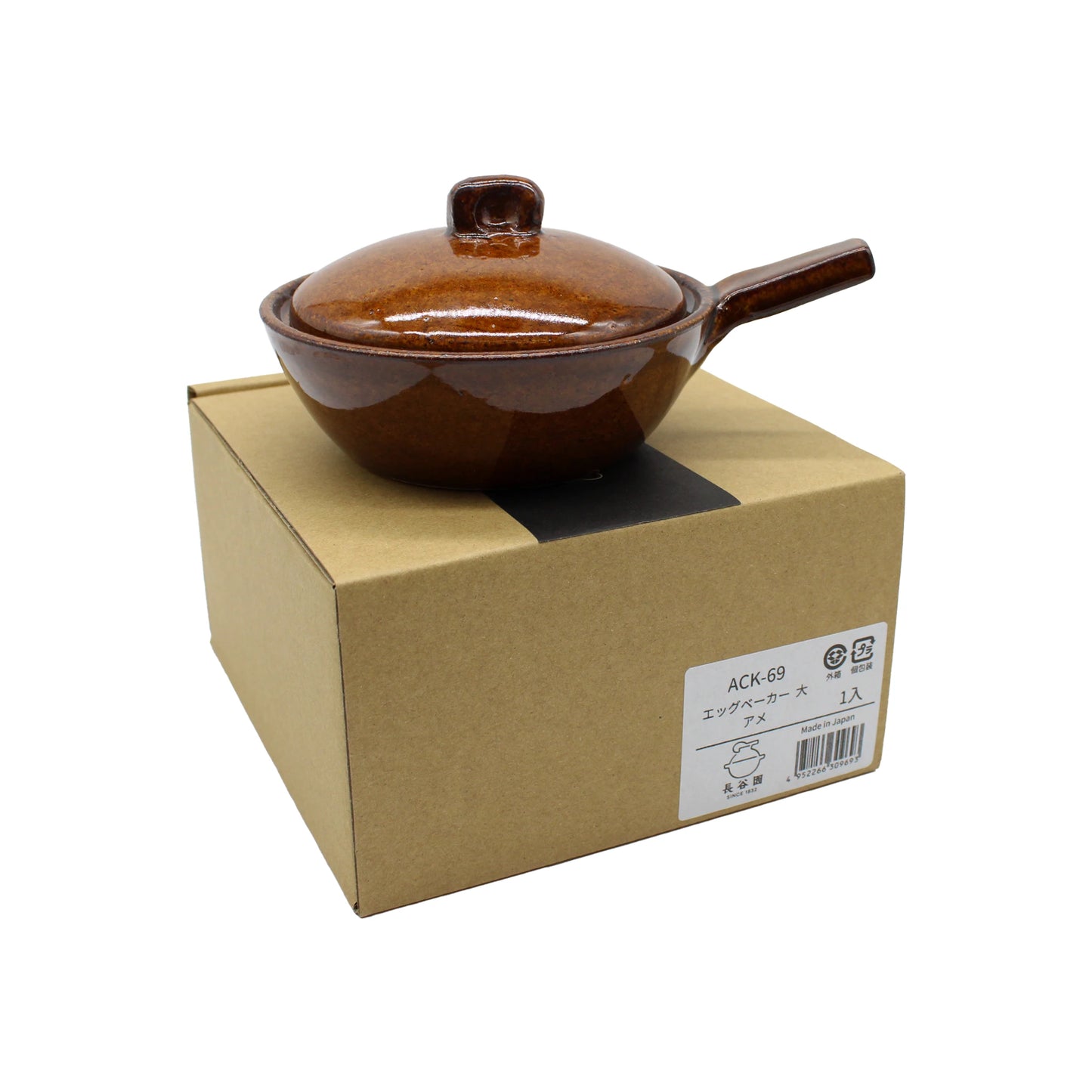 
                  
                    The Mini Baking Dish - Ame is a brown ceramic pot with a lid and handle, designed in the style of a Japanese mini baking dish. It sits atop a plain cardboard box featuring a white label with Japanese text and product information. This versatile piece is ideal for individual baked dishes and is safe for use in both oven and microwave.
                  
                