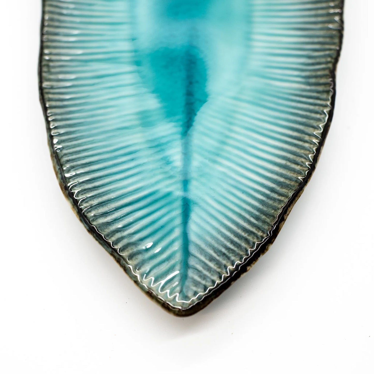 Close-up of the tip of the Sashimi Platter - Oval in Sky Blue 32cm, made from translucent Minoyaki porcelain with blue-green tones, radial ridges, and a glossy finish, set against a white background.