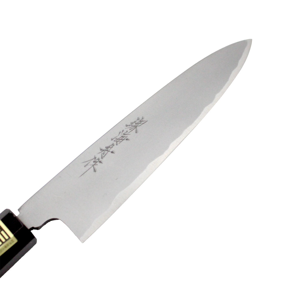 
                  
                    Close-up of the Petty Paring Knife Migaki Polished - 150mm, featuring kanji characters on its white steel blade and a sharp double-bevel edge.
                  
                