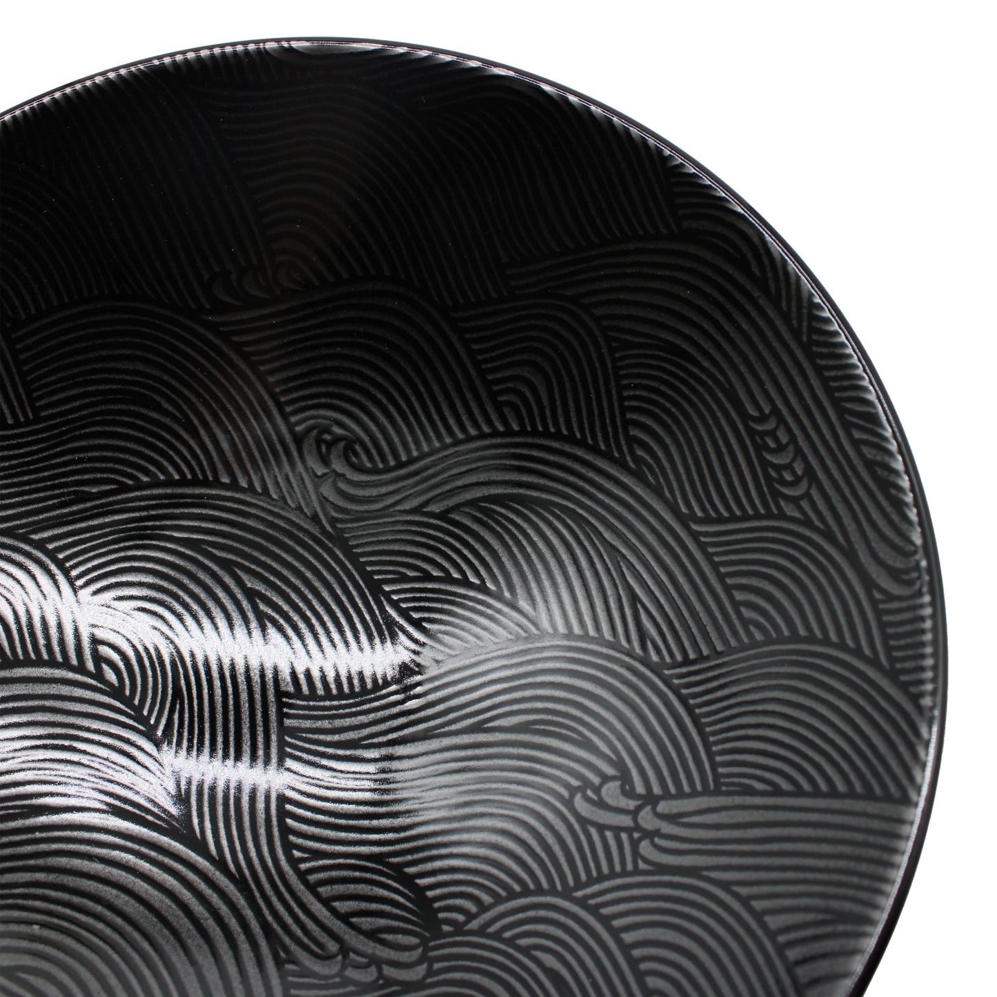 Close-up of the Ramen Bowl - Black Wave, a round, black porcelain bowl featuring an etched, wavy line pattern that creates a textured, abstract design.