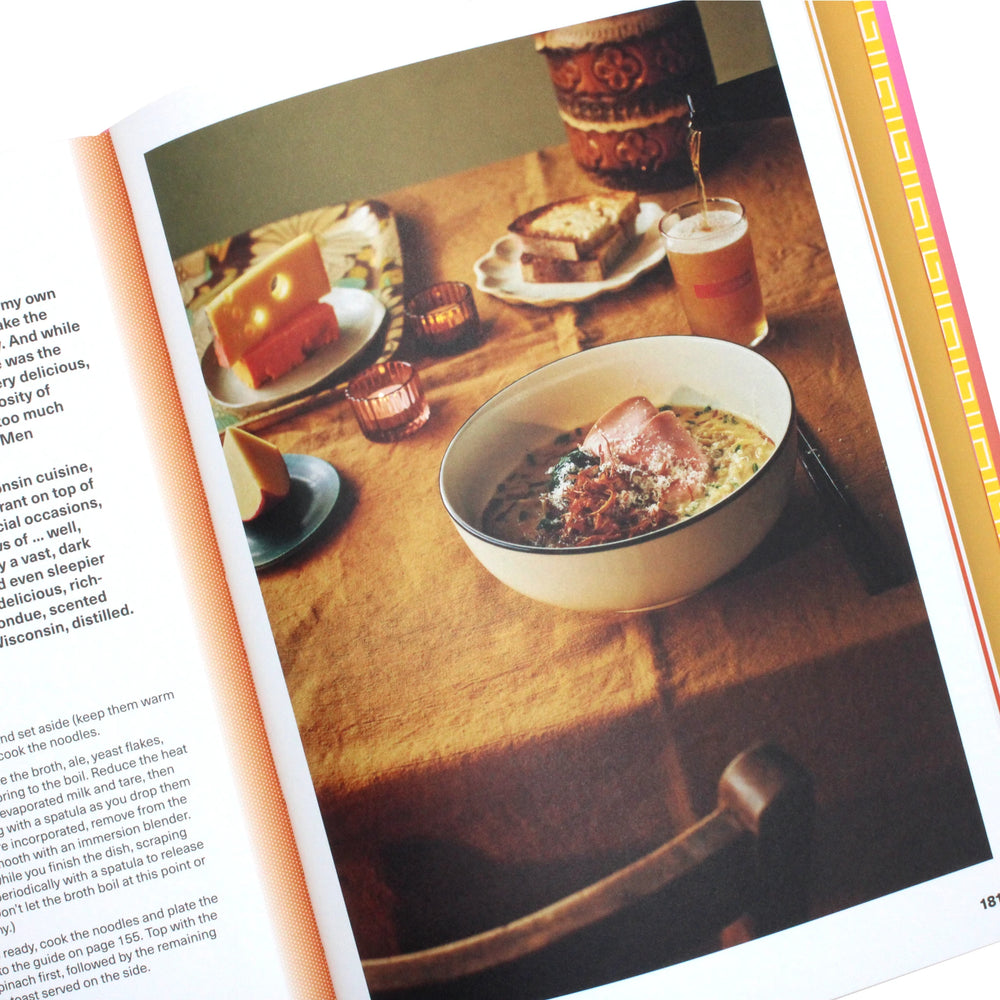 
                  
                    A bowl of homemade ramen with herbs and cheese is served on a set table with orange juice, bread, and candles, as featured in the "Ramen Forever Cookbook" by Tim Anderson.
                  
                
