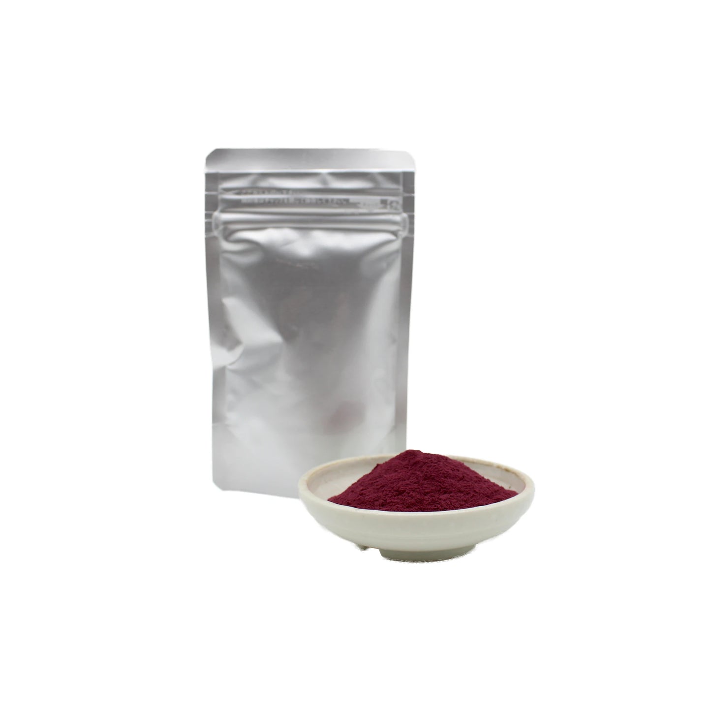 A white bowl of vibrant red Maple Leaf, Freeze Dried Powder - 50g sits before a sealed silver pouch on a white background. This natural powder is made from Japanese red maple leaves.