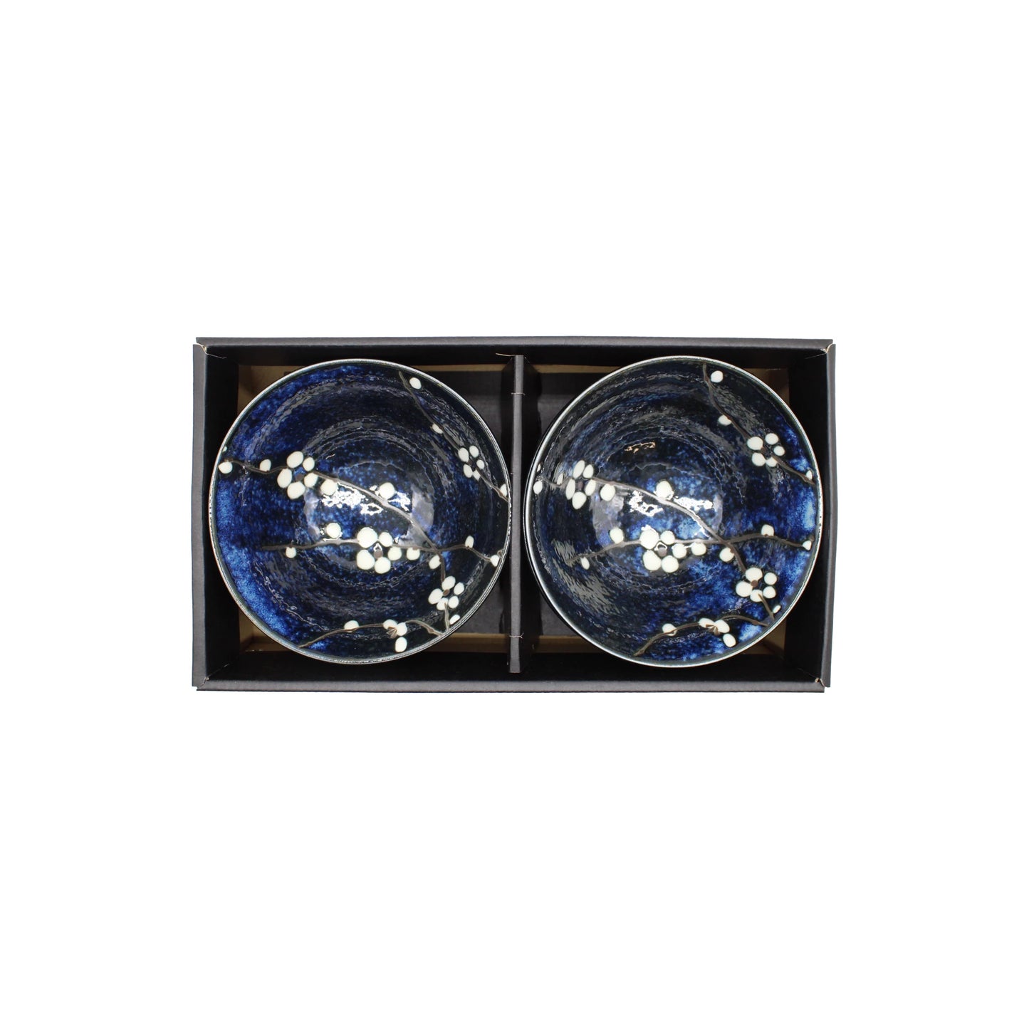 The Blue Cherry Blossom Rice Bowl Gift Set features two blue Japanese rice bowls with white cherry blossom designs, presented side by side in a sleek black rectangular box—a stunning ceramic gift.