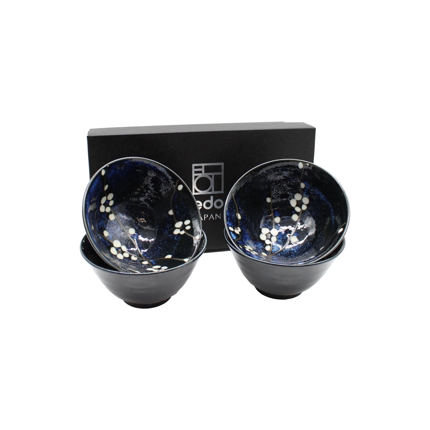 The Blue Cherry Blossom Rice Bowl Gift Set includes four dark blue Japanese rice bowls with white cherry blossom designs, beautifully presented in front of a black Edo Japan box—an ideal ceramic gift for any occasion.