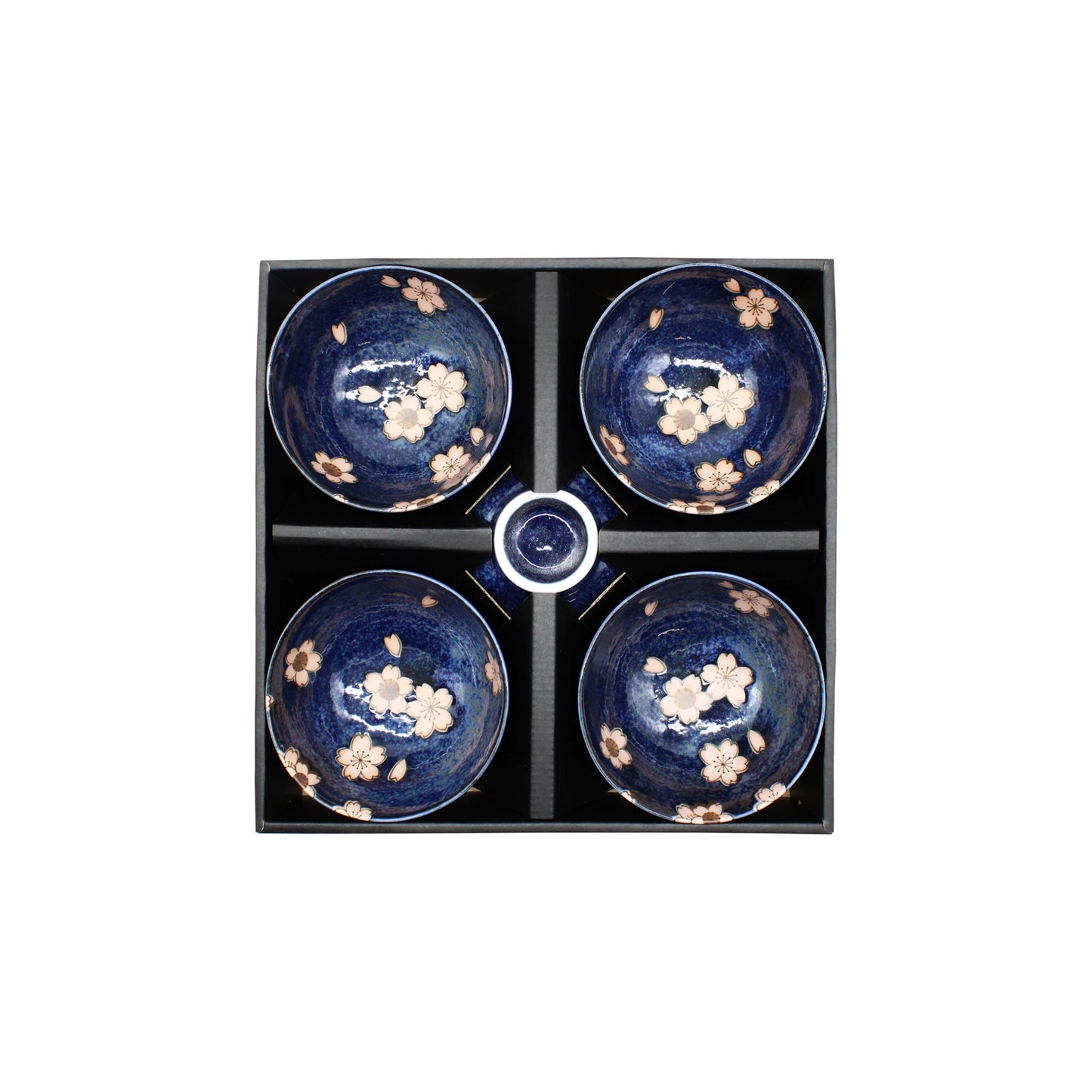 A beautifully arranged Rice Bowl Gift Set - Navy Blue & Pink Sakura featuring four navy blue ceramic rice bowls adorned with delicate pink cherry blossom designs and a small matching dish, all presented in a black box with dividers—an elegant gift set perfect for any occasion.