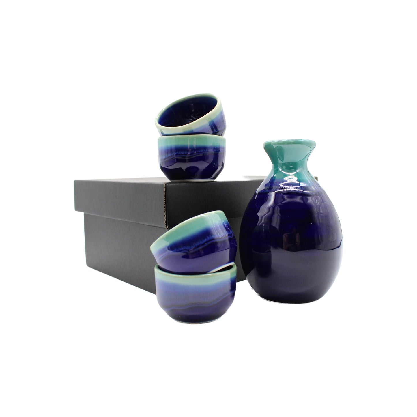 The Sake Gift Set For Four - Cobalt Blue & Teal includes four cups and a matching bottle with cobalt blue and teal glaze, displayed next to a black box on a white background.