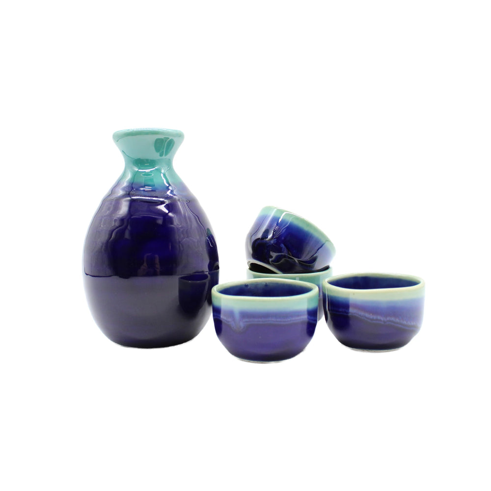 
                  
                    The Sake Gift Set For Four - Cobalt Blue & Teal features a ceramic bottle with an artisanal finish and cobalt blue glaze, accompanied by four matching cups, beautifully displayed on a white background.
                  
                