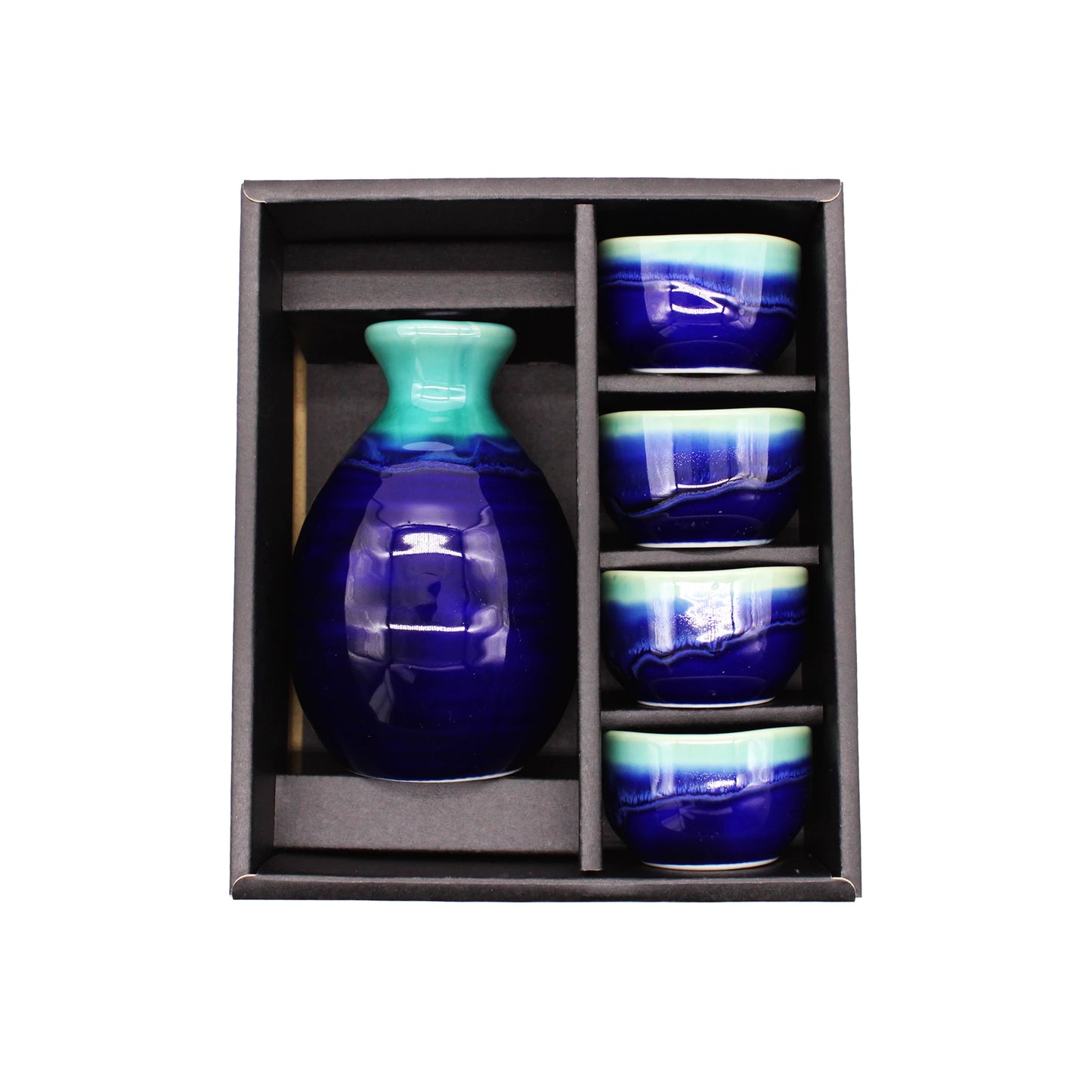 The Sake Gift Set For Four - Cobalt Blue & Teal includes a sake bottle and four artisanal cups in matching hues, all elegantly arranged in a sleek black tray.