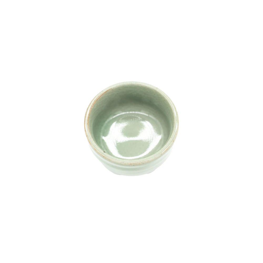 
                  
                    The Sake Cup - Celadon Green is a small, round Minoyaki porcelain cup with a glossy light green finish, shown from above on a plain white background.
                  
                