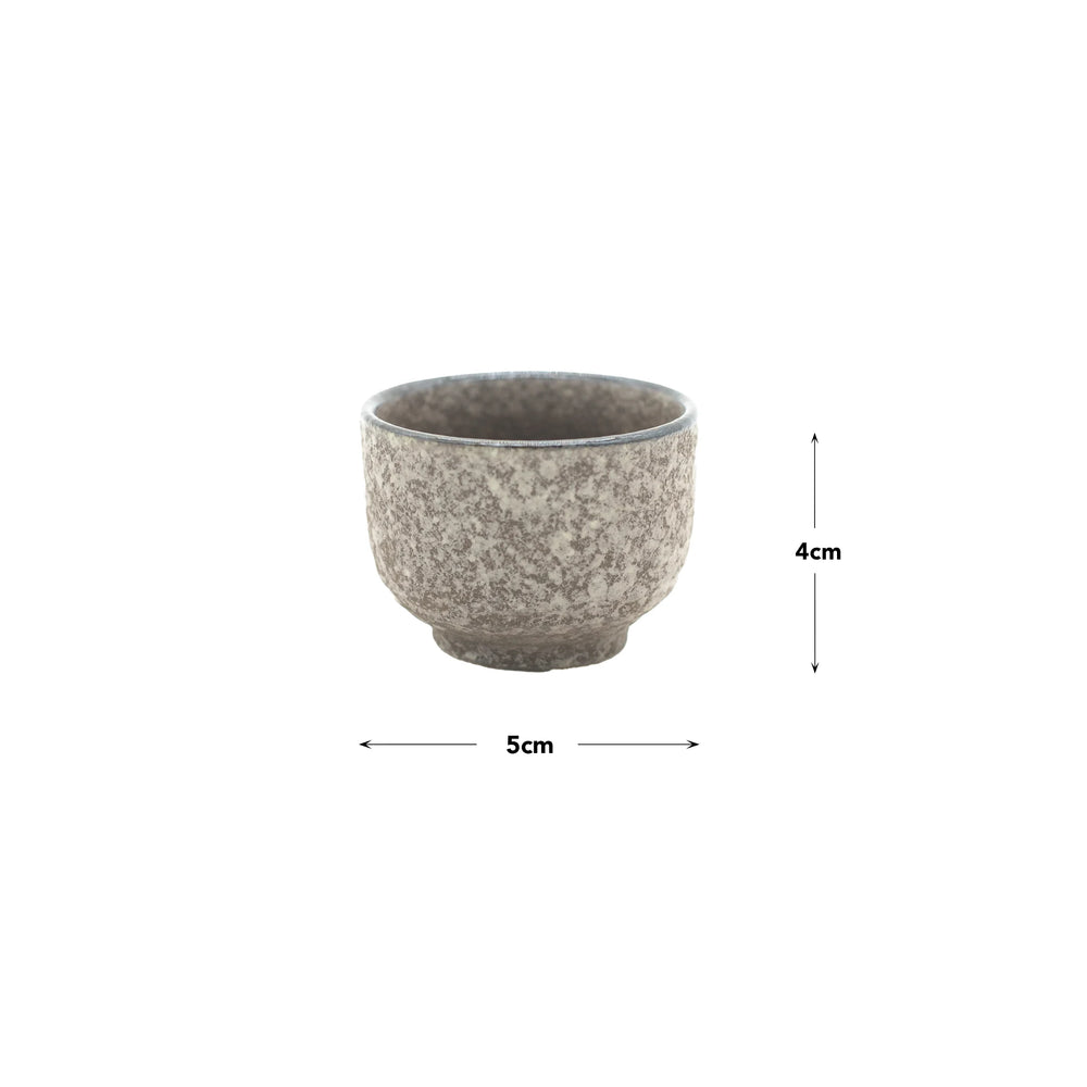 The Sake Cup - Earth is a small gray speckled Minoyaki porcelain cup (5 cm wide, 4 cm tall), showcasing Japanese ceramic craftsmanship. Displayed on a plain white background, its perfect as an earth-inspired sake cup.