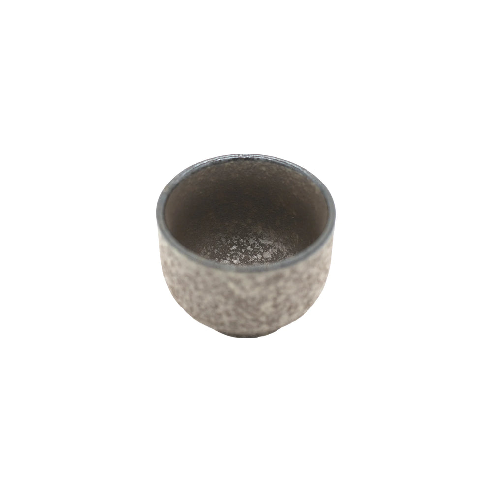 
                  
                    The Sake Cup - Earth is a small, gray, textured cup with a rounded shape that highlights Japanese ceramic craftsmanship, set against a plain white background.
                  
                
