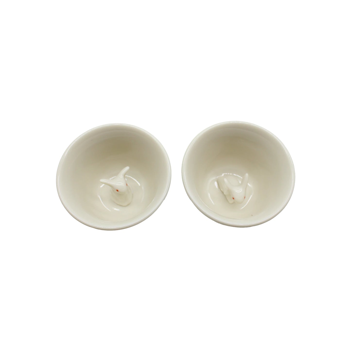 
                  
                    Two white ceramic sake cups from the Sake Cup Boxed Set - Rabbit Design, each featuring a delicate rabbit motif and a small rabbit figurine inside, elegantly displayed from above on a plain white background.
                  
                