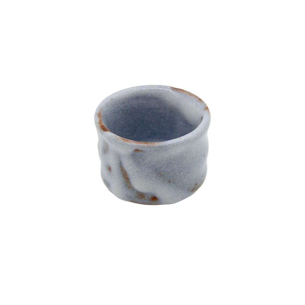 The Sake Cup - White Cloud is a small, round Minoyaki porcelain cup featuring a textured ceramic surface with a light blue glaze and brown spots, highlighting Japanese craftsmanship against a plain white background.