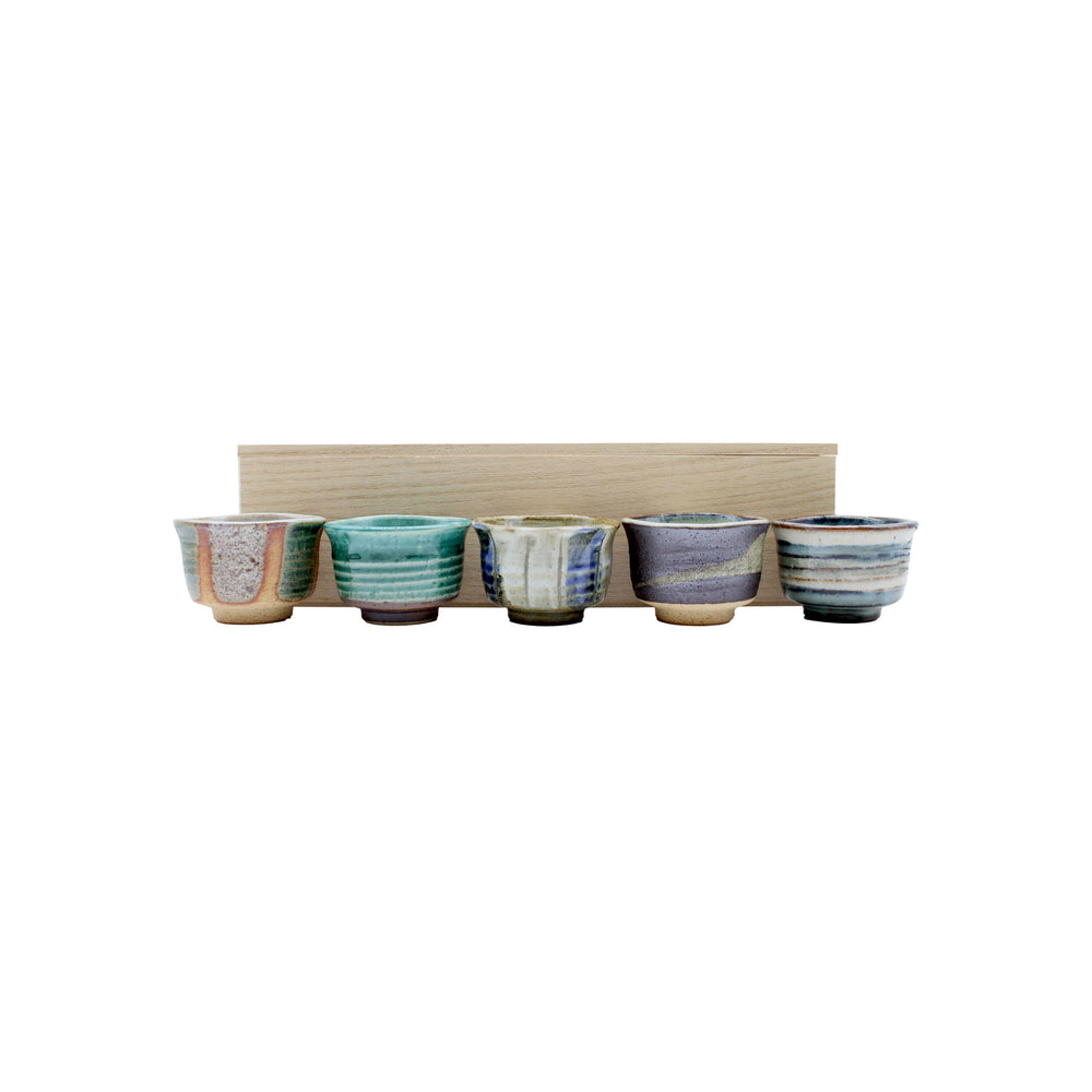 
                  
                    The Ochoko Sake Cups - Set of 5 features five small, multicolored cups arranged before a light wooden box on a white background, reflecting Japanese ceramic tradition.
                  
                