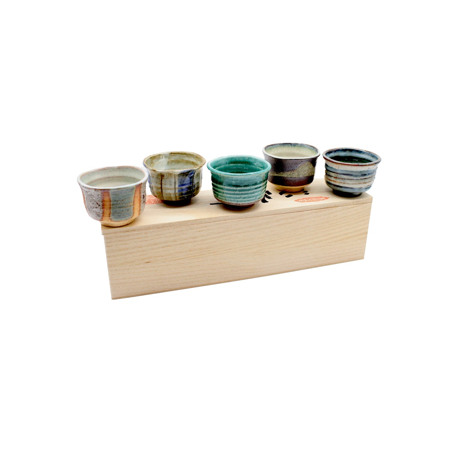 
                  
                    The Ochoko Sake Cups - Set of 5 features small cups with unique earthy and blue-green glazes, displayed on a rectangular light wooden box, reflecting Japanese ceramic tradition against a white background.
                  
                