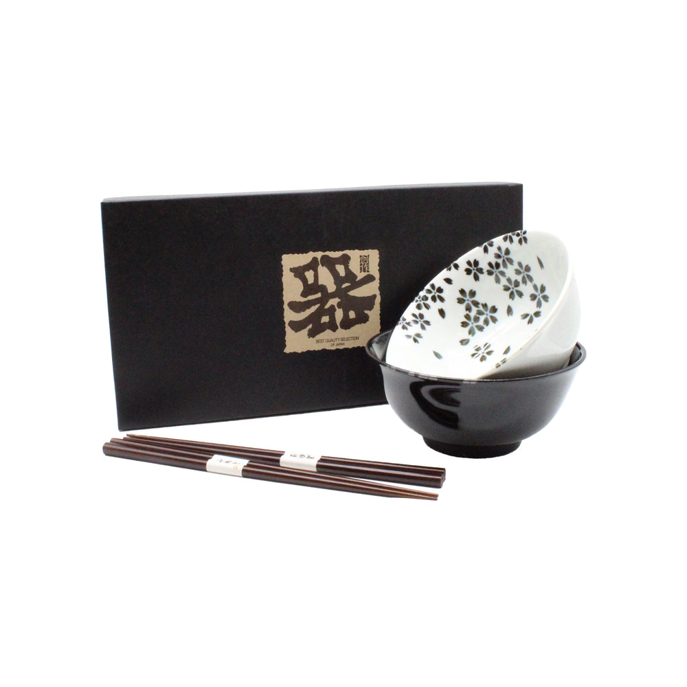 
                  
                    The Sakura Blossom Bowls Gift Set – Black & White features two ceramic bowls (one with a sakura motif, one solid black), presented in front of a black box with Japanese writing, and includes two pairs of chopsticks.
                  
                