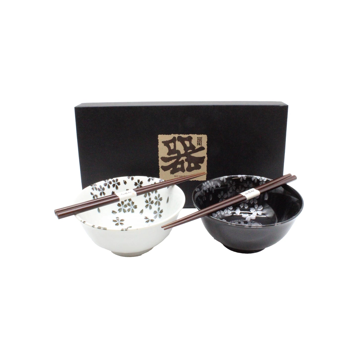 The Sakura Blossom Bowls Gift Set – Black & White includes two ceramic bowls with sakura motifs (one white, one black), each paired with chopsticks and presented in a black box with Japanese writing.