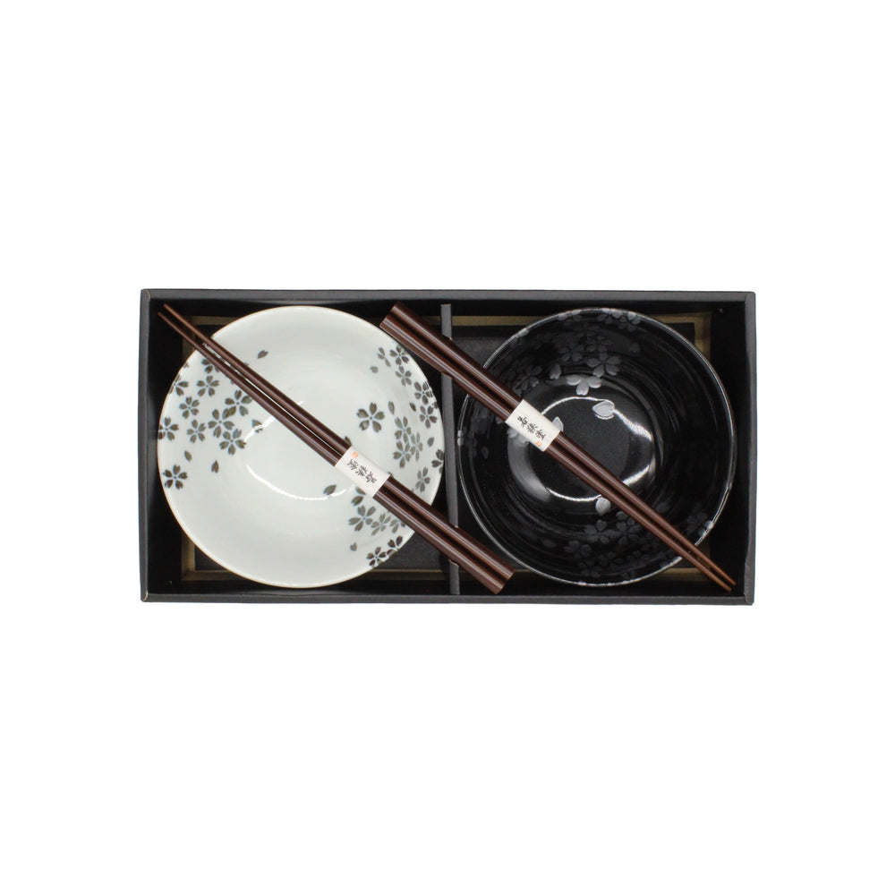 
                  
                    The Sakura Blossom Bowls Gift Set – Black & White includes ceramic bowls—one black, one white—and two pairs of chopsticks, beautifully arranged in a sleek black rectangular box and shown from an overhead view.
                  
                