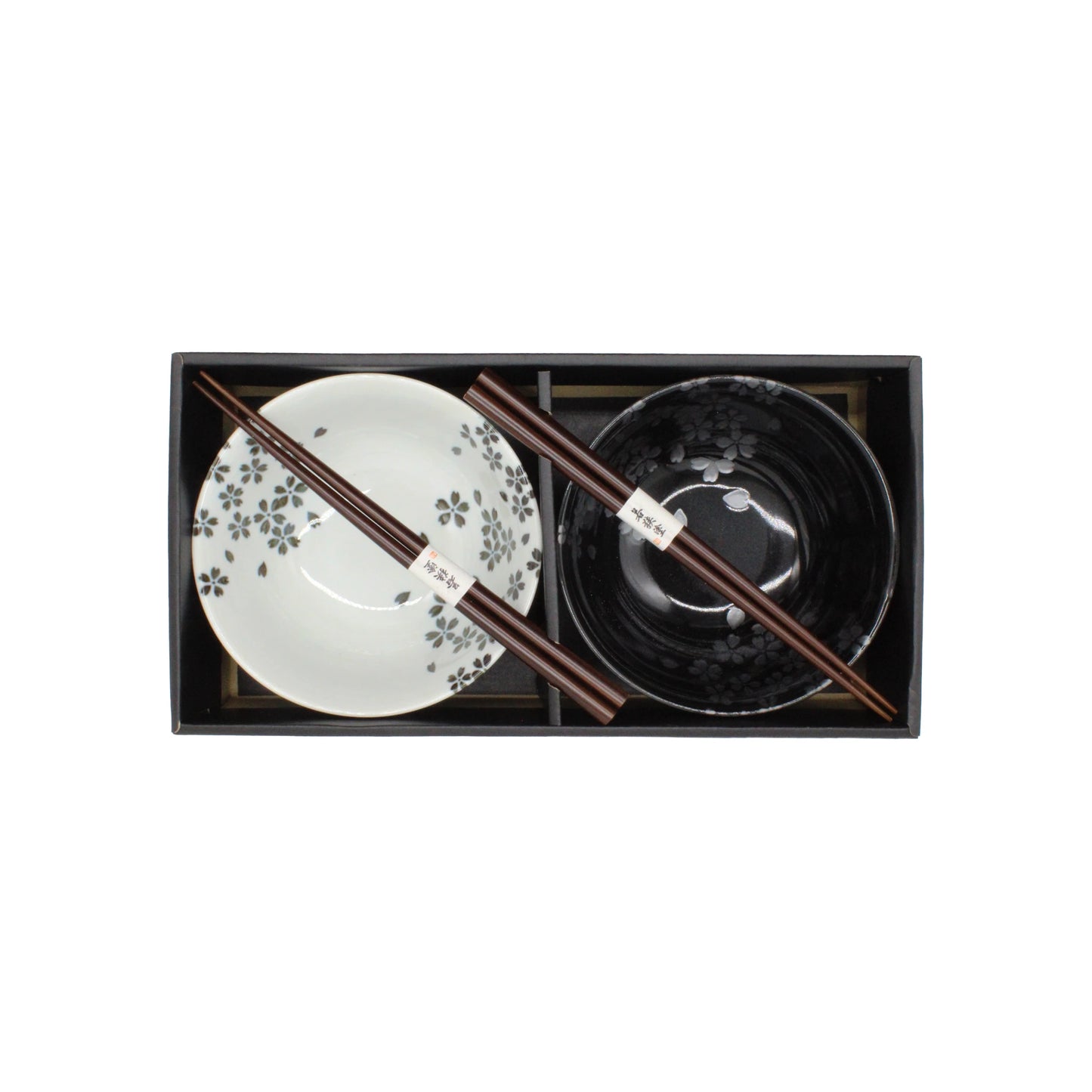 
                  
                    The Sakura Blossom Bowls Gift Set – Black & White includes ceramic bowls—one black, one white—and two pairs of chopsticks, beautifully arranged in a sleek black rectangular box and shown from an overhead view.
                  
                
