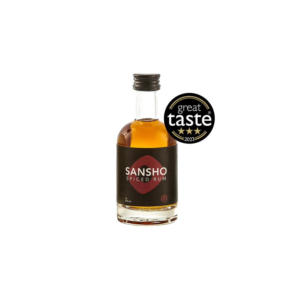 A 5cl bottle of Sansho Spiced Rum, infused with distinctive Japanese flavors and adorned with a black and red label, is displayed next to a “Great Taste 2023” award badge.