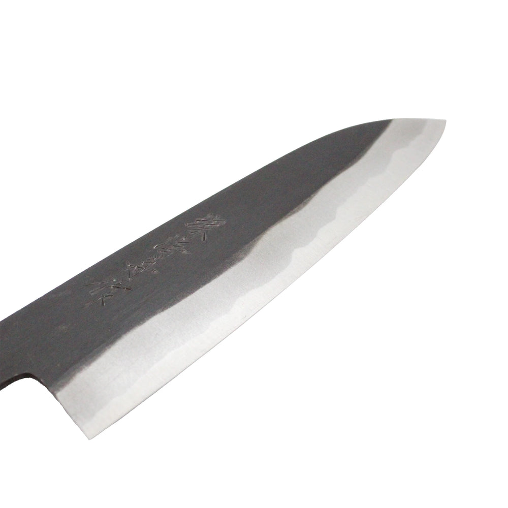 
                  
                    Close-up of the Santoku Multi-Purpose Knife Black Forged 180mm blade, featuring engraved characters, a straight double-bevel edge, and a unique wavy pattern along the sharpened area.
                  
                