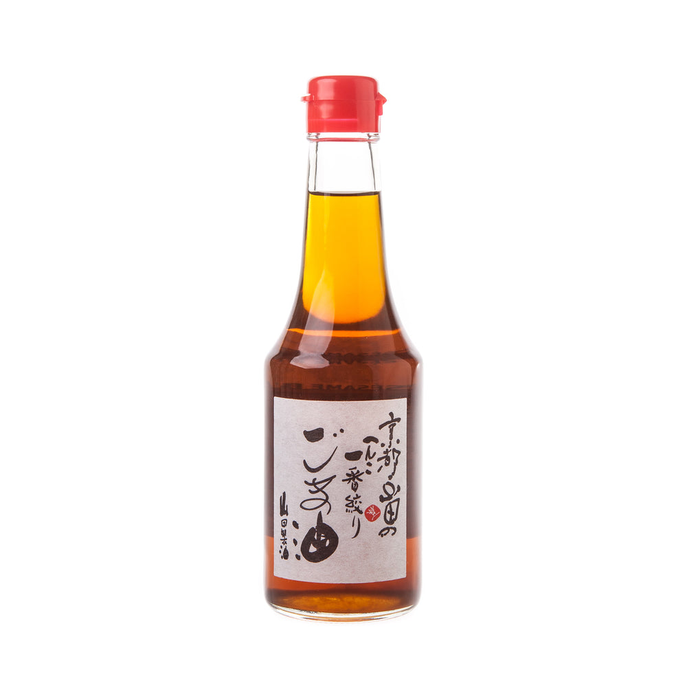 A 300ml clear glass bottle of White Sesame Oil with amber liquid, red cap, and a white label featuring Japanese text is displayed on a white background—ideal for elevating dishes cooked in wood fired ovens.