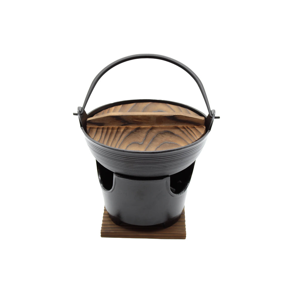 The Shabu Shabu Pot - 17cm is a small black pot with a wooden lid and handle, ideal for Japanese hot pot or serving dashi broth. It sits on a square wooden base, shown against a white background.
