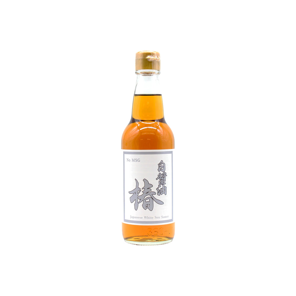 A clear glass bottle of Shiro Shoyu Tsubaki, White Soy Sauce, essential in Japanese cuisine, with a gold cap and white label, is photographed on a plain white background.