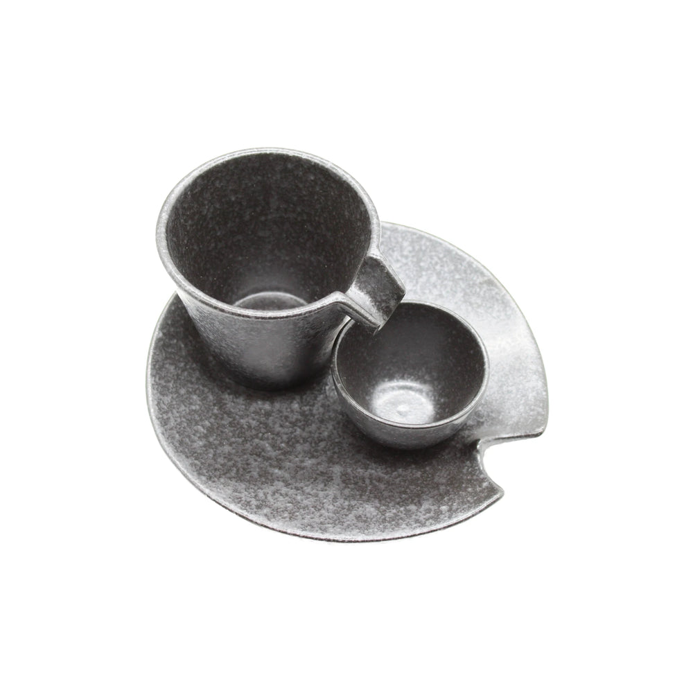 
                  
                    The Shizuru Sake Set - Black & Silver by Kaneko Ko-hyo, ideal for sake enthusiasts, is displayed on a matching round saucer featuring a small edge notch, all set against a white background.
                  
                