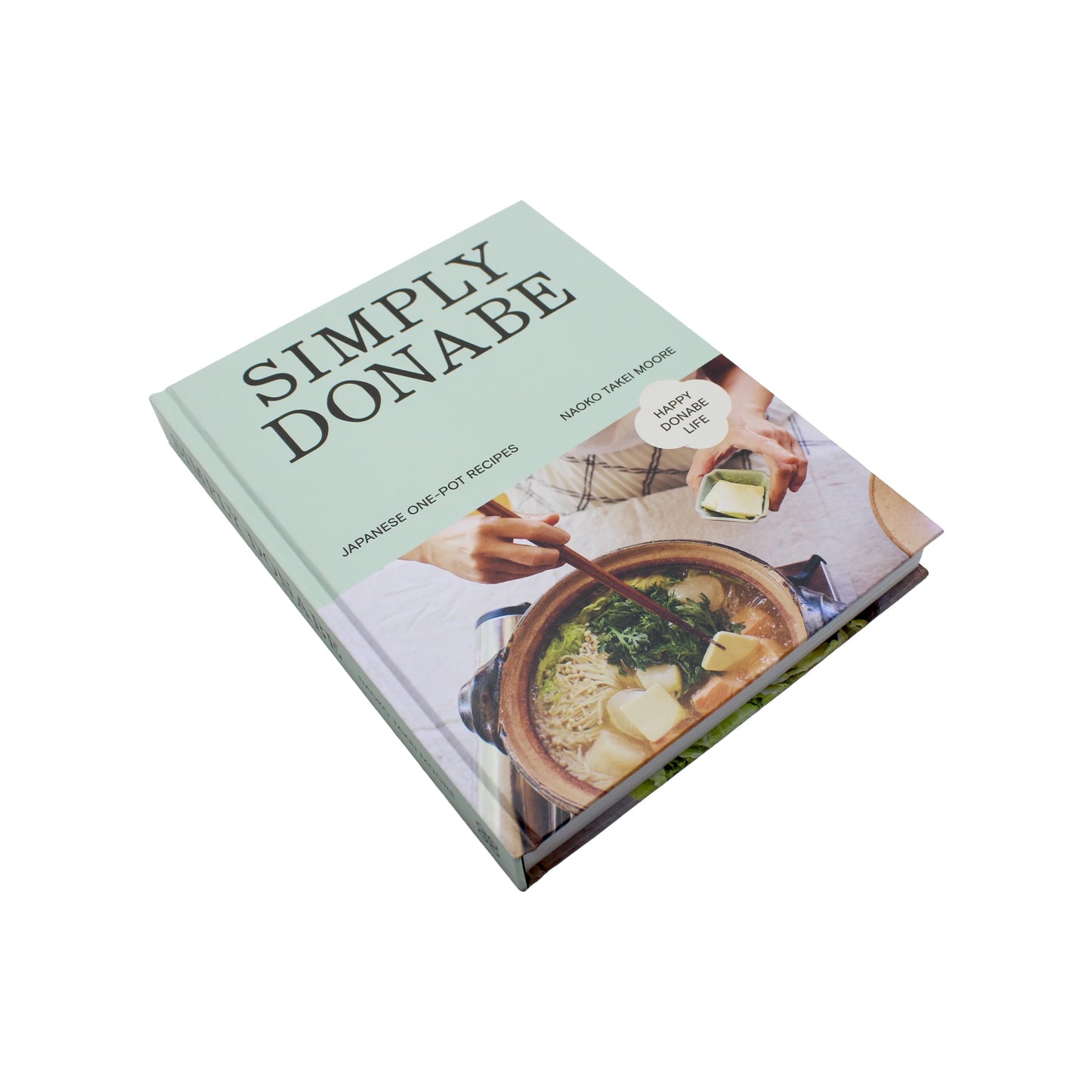 A hardcover cookbook, Simply Donabe - Japanese One Pot Recipes by Naoko Takei Moore, features a cover photo of hands preparing food in earthenware pots.