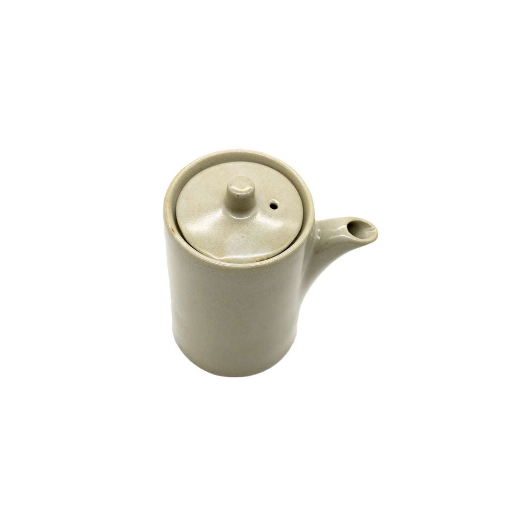 
                  
                    A handmade beige ceramic Soy Sauce Pourer - Stone with a lid and spout, inspired by Minoyaki porcelain, photographed from above on a plain white background.
                  
                