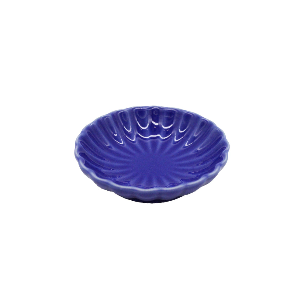 A small, round, blue ceramic soy sauce dish featuring a scalloped edge and radiating chrysanthemum design, handcrafted in Japan.