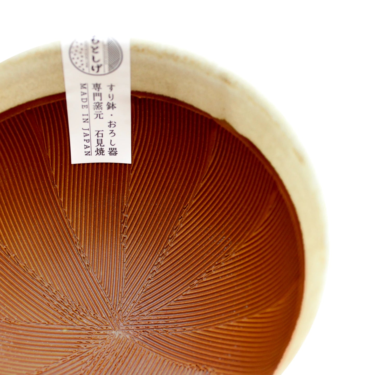 
                  
                    Close-up of a white Suribachi Motoshige pestle & mortar, showing its fine ridged interior texture and a label with Japanese text and MADE IN JAPAN printed on it.
                  
                