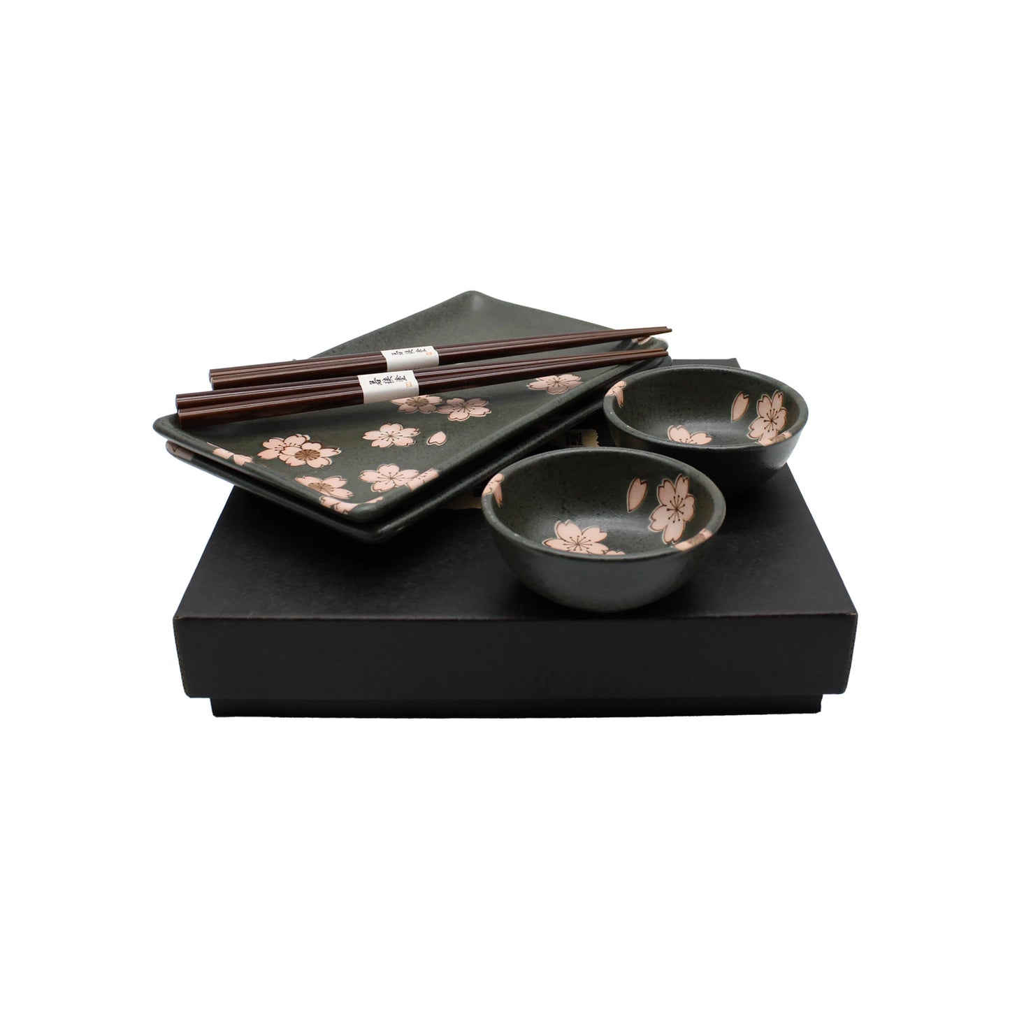 The Sushi Gift Set - Black & Pink Sakura Design includes Japanese ceramic sushi plates, two pairs of chopsticks, two small bowls, and two square plates with pink sakura patterns, all elegantly presented in a sleek black box.