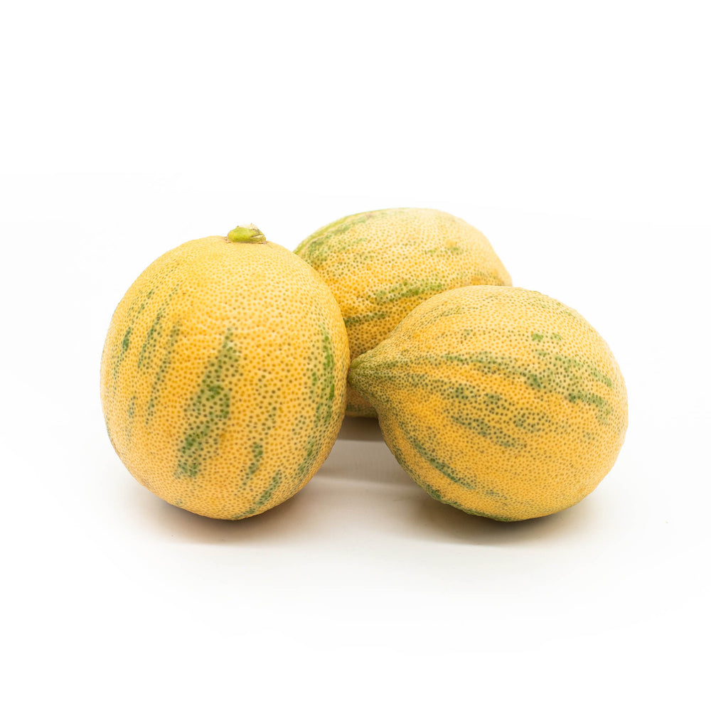 Three Fresh Tiger Lemons, featuring green streaks and a subtle floral fragrance, are displayed on a white background.