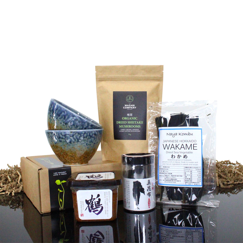 The Miso Soup Kit with Miso Bowls includes kombu seaweed, dried shiitake mushrooms, two miso bowls, and two condiment containers, all neatly arranged together.